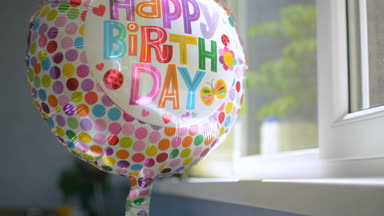 Mutlu Doğum günü partisi kutlama balon vasıl pencere yansıtan güneş ışığı döndürme