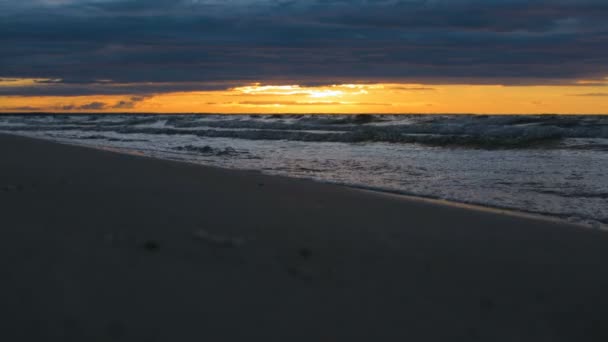 Vodní vlny přicházející v detailním na břehu moře v epické dramatický západ slunce světlo — Stock video