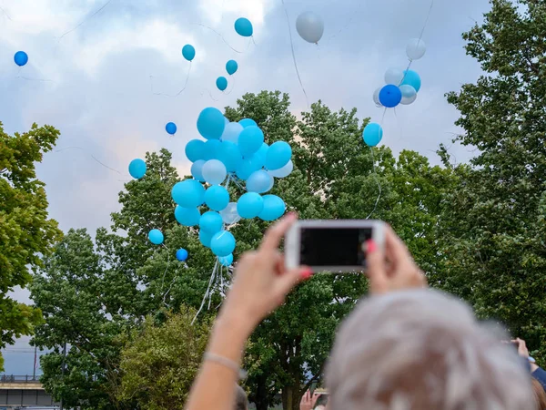 Helyum balon göğe uçmak ve kadın bunu bir cep telefonu ile fotoğraf çekimi