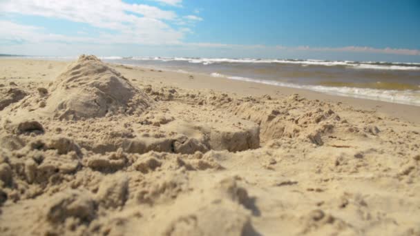 Самотня піщана фортечна піраміда крупним планом на сонячному пляжі мінімалістичний фон — стокове відео