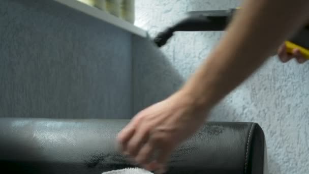 Cleaning sofa using a steam cleaner and a wet cloth. Housekeeping concept. — Stock Video