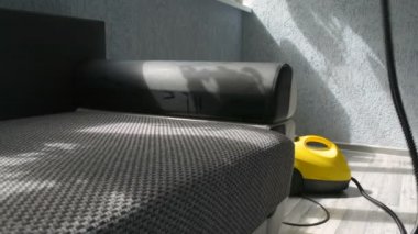 Kanepe ile bir buhar temizleyici su buharı bir profesyonel tarafından temizlik. Ev concept.