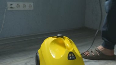 Çalışan bir buhar aygıt temizleme kullanarak bir erkek el closeup. Ev, modern ev kavramı temizlik
