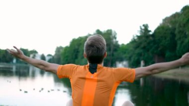 Breating, Kaldır ellerini yükselterek parkta oturan genç Yoga, yaparken meditasyon