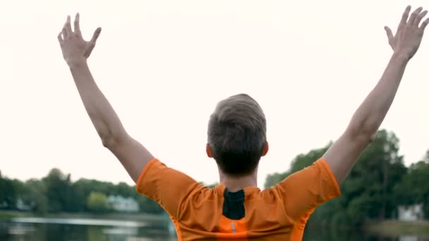 Levantando as mãos no ar respirando ar fresco após o exercício pesado ao ar livre — Vídeo de Stock