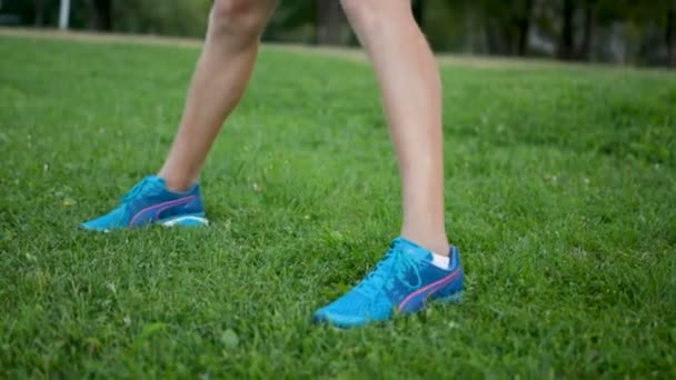 Mladý sportovec strething před dlouhou distane maraton běžet venku na zeleném trávníku — Stock video