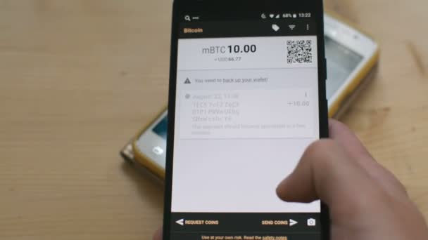 Отправка биткойна между смартфонами путем сканирования QR-кода, будущее розничной транзакции в магазине, концепция цифровых наличных денег — стоковое видео
