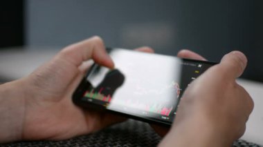 Bitcoin fiyat grafik cep telefonu ekran üzerinde kontrol kanepede döşenmesi, ekran görünümü penceresi yansıma, cryptocurrency gelecekteki fiyat eylem tahmin kavramı ile tıkalı