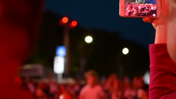 Riga, srpen 2018: Nahrávání videa s mobilním telefonem iphone během rocková kapela hudební výkon koncert na jevišti — Stock video