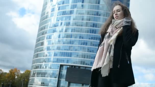 Mladá dáma nízký úhel portrét s novostavbou na pozadí — Stock video