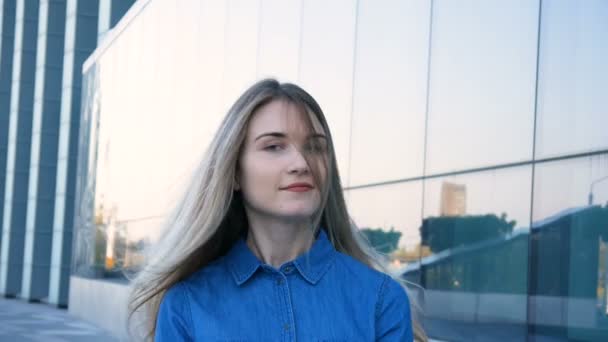 Kamera ve gülümsüyor için muhteşem bir uzun sarı saçlı ve mavi gözlü çekici genç kadın döner — Stok video