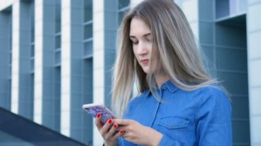 Onun cep telefonu, smarthone, manifatura önünde bir modern kentsel şehir mimarisi kullanarak güzel Bayan