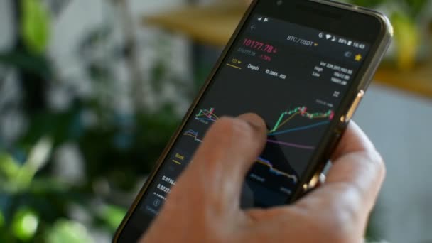 Homme d'affaires vérifie Bitcoin tableau des prix sur l'échange cryptographique sur l'écran de téléphone mobile. Crypto-monnaie concept de prévision des prix futurs . — Video