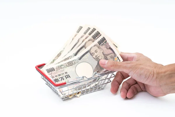 Hombre mano agarrando japonés 10000 billete en la cesta de la compra en —  Fotos de Stock