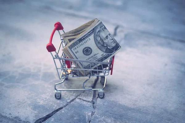 Carrito de compras con billete de dólar USD en piso de crack con retro —  Fotos de Stock