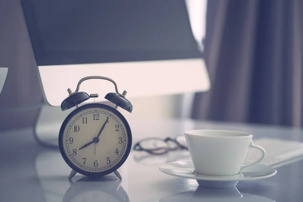 Office work space computer desk with coffe and clock, vintage co Stock Picture