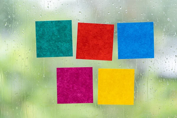 Bianco adesivo colorato bastone nota sulle finestre in giorno di pioggia — Foto Stock