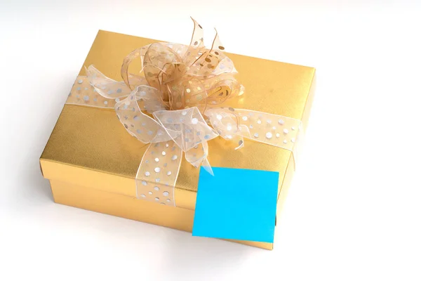 Blank adhesive note on gold gift box on white background — Stock Photo, Image