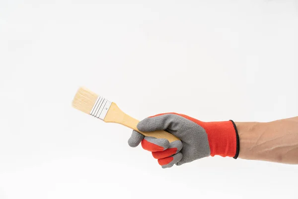 Mão homem com luva anti derrapante vermelho segurando pincel de pintura — Fotografia de Stock