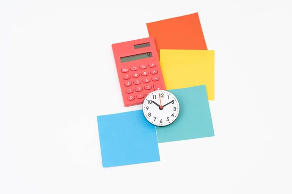 Post-it colorido en blanco con calculadora y reloj — Foto de Stock