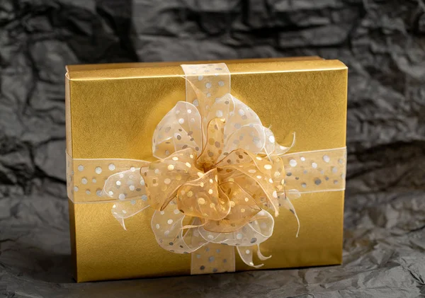 Kotak hadiah emas pada latar belakang hitam — Stok Foto