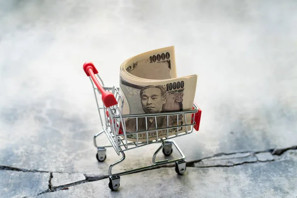 Shopping cart of ten thousand Yen banknote on broken floor. cris — Stock Photo, Image