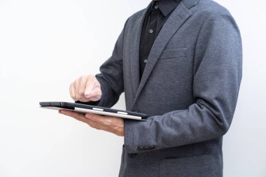 Beyaz artalan üzerinde tablet bilgisayar kullanarak işadamı tanınamaz