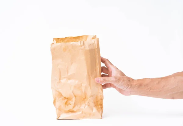 Homem mão segurando saco de papel marrom no fundo branco — Fotografia de Stock