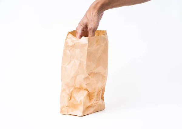Homme cueillette à la main dans un sac en papier brun sur fond blanc — Photo