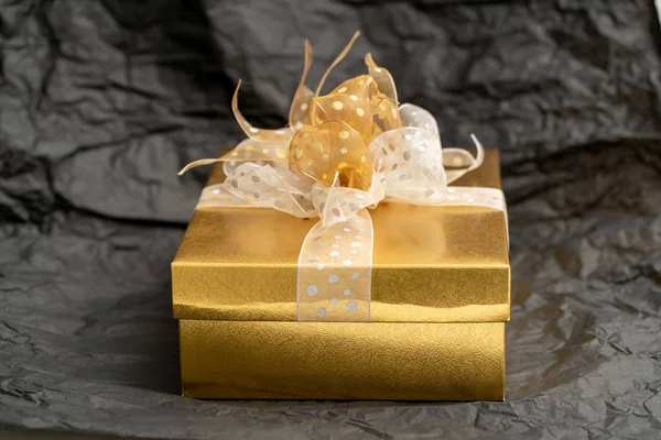 Caixa de presente de ouro no fundo preto — Fotografia de Stock