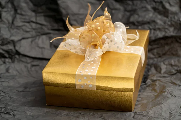 Caixa de presente de ouro no fundo preto — Fotografia de Stock