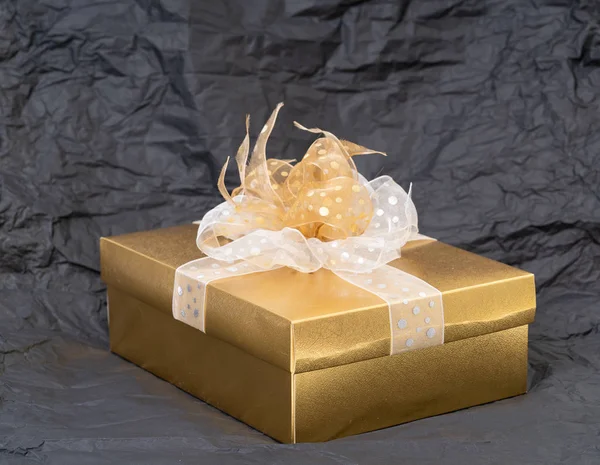 Золотая подарочная коробка на черном фоне — стоковое фото