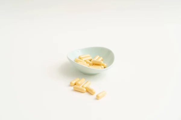 Gelbe Kapsel Pillen auf weißem Hintergrund — Stockfoto