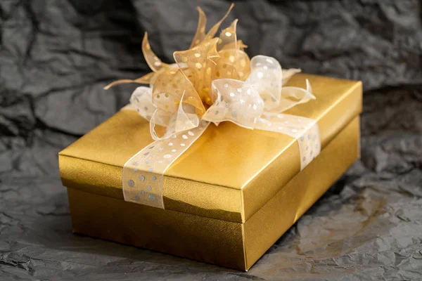 Золотая подарочная коробка на черном фоне — стоковое фото
