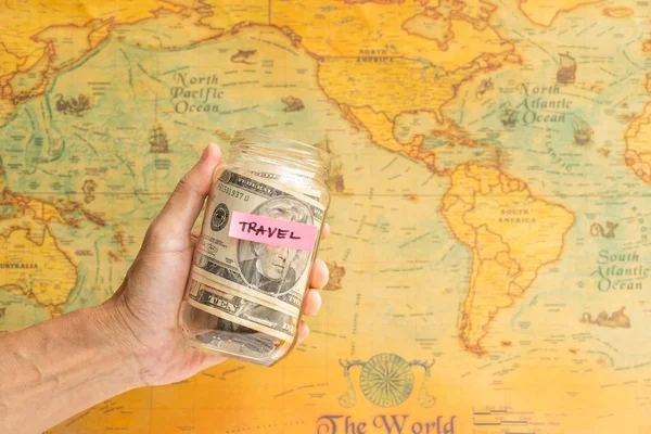 Dinero para viajar Mano sosteniéndonos. dólar con mapa vintage —  Fotos de Stock