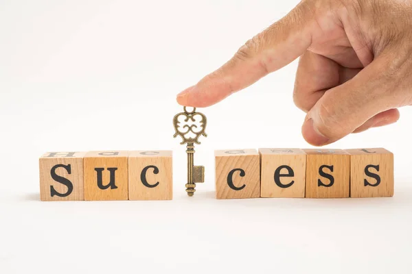 Wood block success word  with hand and key on white background. — Stock Photo, Image