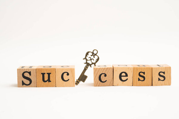 Wood block success word with key on white background. for busine