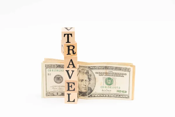 Holzblock Reisewort mit Dollarschein auf weißem Hintergrund — Stockfoto