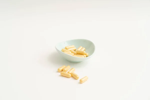 Yellow capsule pills on white background — Stock Photo, Image