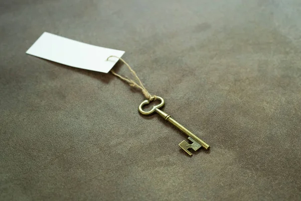 白いタグが付いている古いヴィンテージ真鍮のキー — ストック写真
