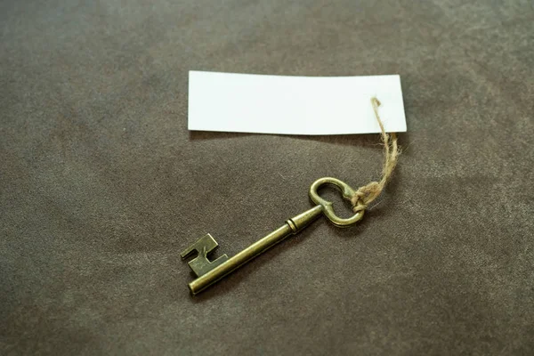 Antiguo llave de latón vintage con etiqueta blanca —  Fotos de Stock