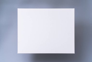 Gri arkaplanda boş beyaz tuval çerçeve