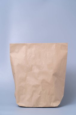 Gri arkaplandaki kahverengi kağıt torbayı geri dönüştür