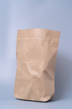 Gri arkaplandaki kahverengi kağıt torbayı geri dönüştür