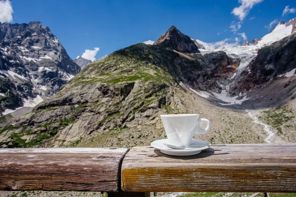 Coffee cup with mountain view, enjoyable break on top of alps