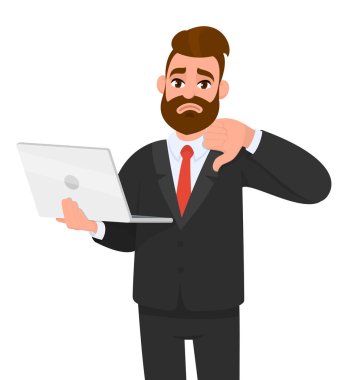 Mutsuz genç sakallı iş adamı tutan / en son yeni dizüstü bilgisayar gösteren ve gesturing / el parmakları ile işaret aşağı başparmak yapma. Sevmemek, kötü, negatif, modern teknoloji, dijital cihaz/gadget konsepti