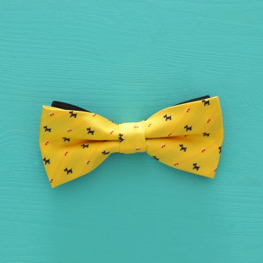 Mavi ahşap arka plan üzerinde sarı erkek papyon üstten görünüm