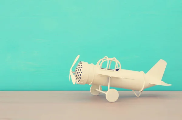木製テーブル青い背景上のレトロなホワイト メタル グッズ飛行機のイメージ — ストック写真