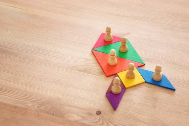 tangram bulmacanın blok ahşap masa, insan kaynakları ve yönetim kavramı üzerinde satranç figürleri ile görüntü