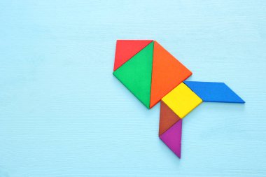 tangram bulmacanın mavi pastel ahşap arka plan üzerinde yapılan roket